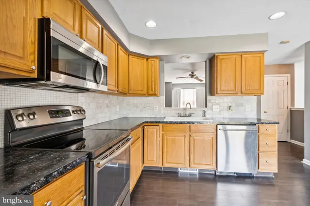 a kitchen with stainless steel appliances granite countertop a sink a stove microwave and cabinets
