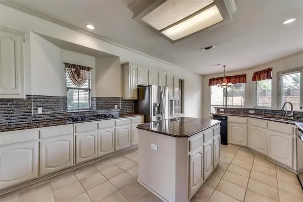 a kitchen with sink a microwave and chairs