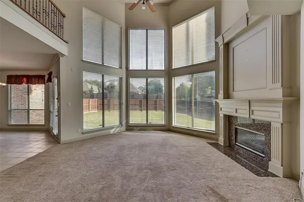 a view of an empty room with a fireplace and a window