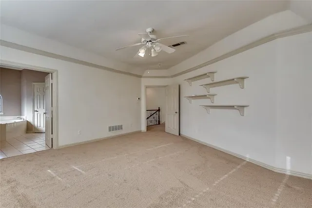 a view of an empty room with a ceiling fan
