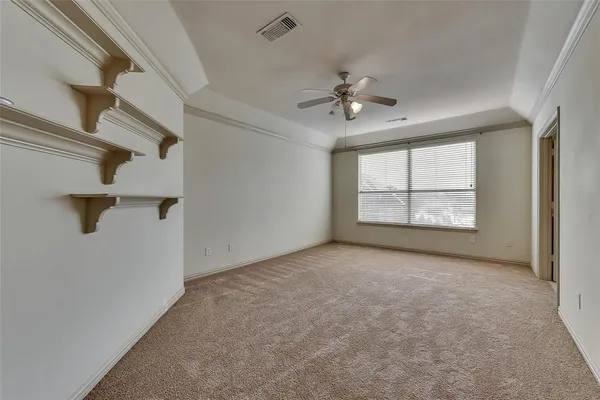 an empty room with windows and ceiling fan