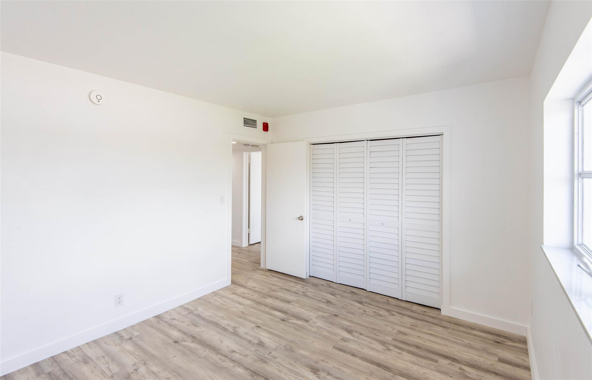 651 Pine Drive, Unit 306 Pompano Beach, FL 33060 - Photo 28 of 36 an empty room with wooden floor and windows