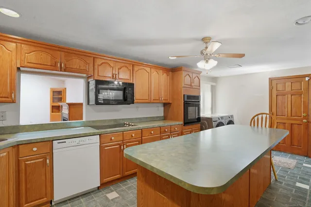 a kitchen with stainless steel appliances granite countertop a kitchen island hardwood floor sink stove dining table and chairs