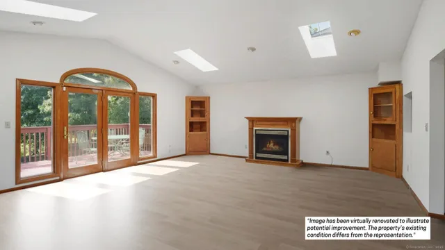 a view of an empty room with a fireplace and a window