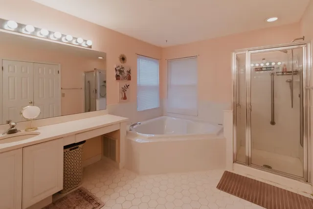 a bathroom with a tub a sink and mirror