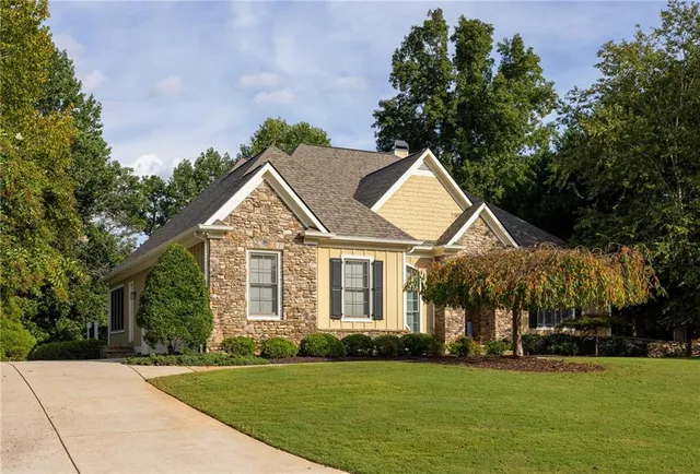 a kitchen with stainless steel appliances granite countertop a stove top oven a sink dishwasher and white cabinets with wooden floor
