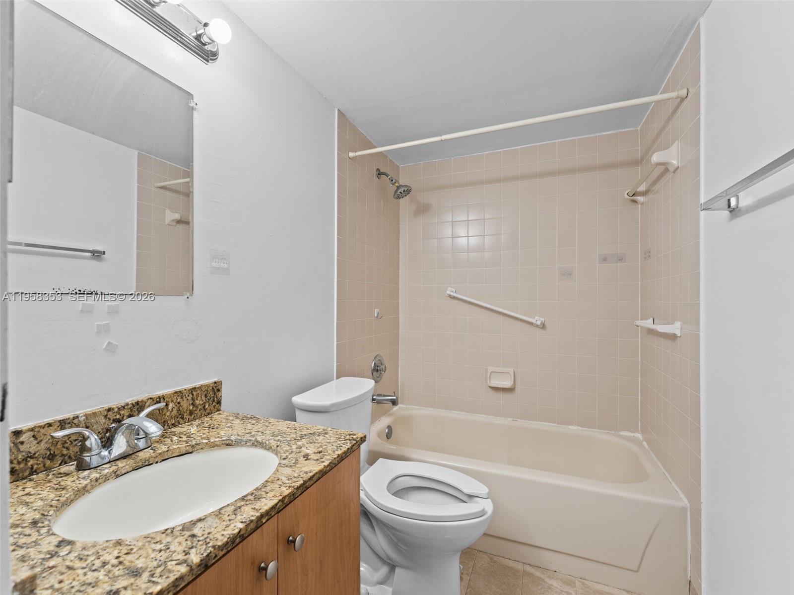 13078 Southwest 88th Lane, Unit B102 Miami, FL 33186 - Photo 10 of 27 a bathroom with a granite countertop sink toilet mirror and shower