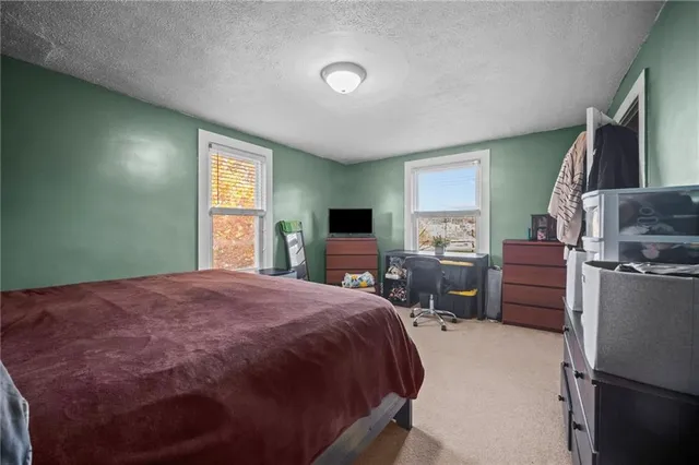 a bedroom with a bed flat screen tv and windows