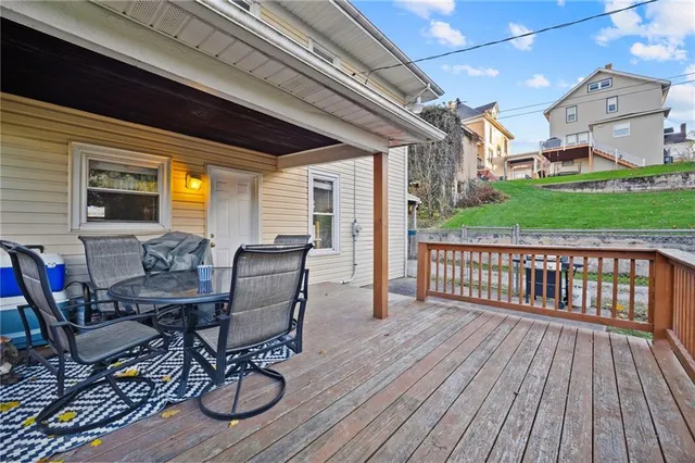 a view of a patio with table and chairs with wooden floor and fence