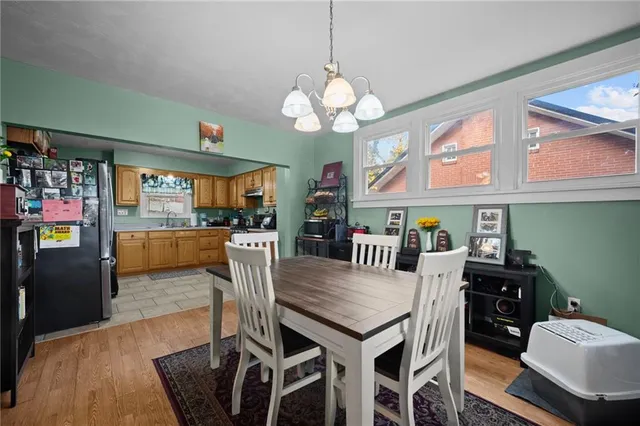 a view of a dining room with furniture a chandelier and wooden floor