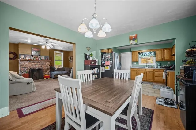 a dining room with wooden floor a chandelier a wooden table and chairs