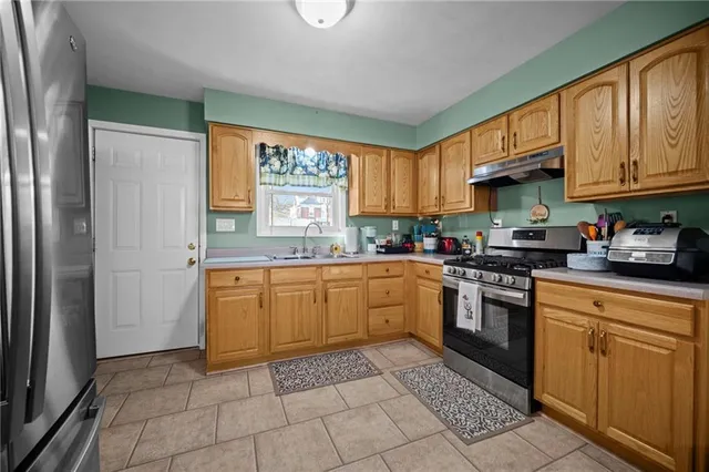a kitchen with stainless steel appliances granite countertop a stove sink and cabinets