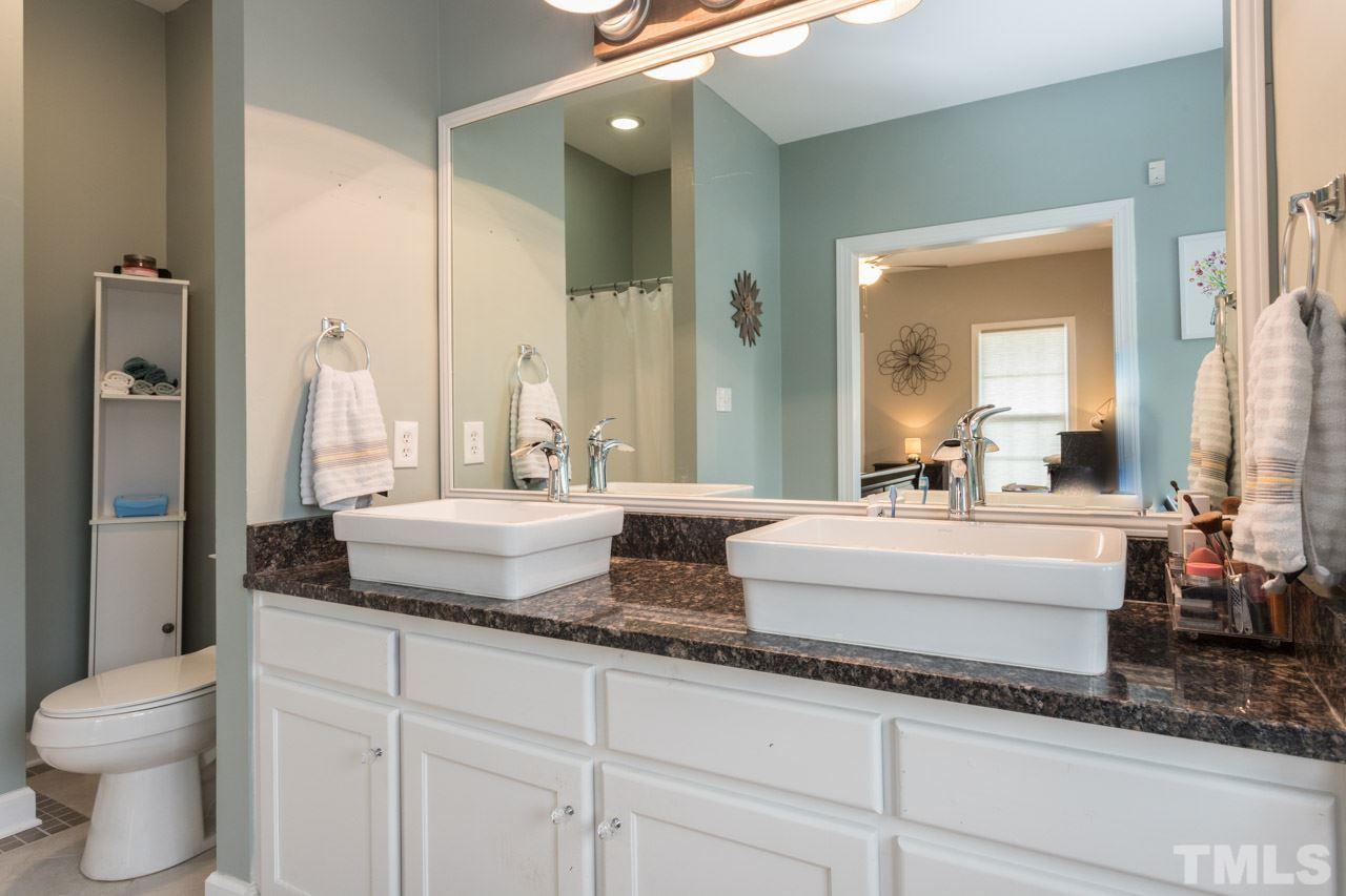 7505 Penny Road Raleigh, NC 27606 - Photo 19 of 25 a bathroom with a granite countertop sink and a mirror