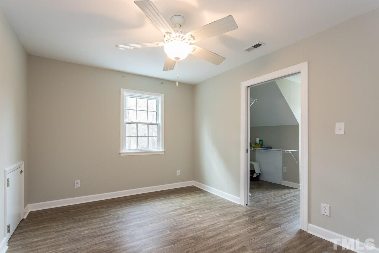 7505 Penny Road Raleigh, NC 27606 - Photo 23 of 25 an empty room with wooden floor and a ceiling fan