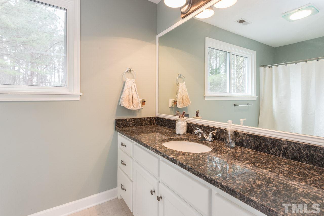 7505 Penny Road Raleigh, NC 27606 - Photo 25 of 25 a bathroom with a granite countertop sink and a mirror