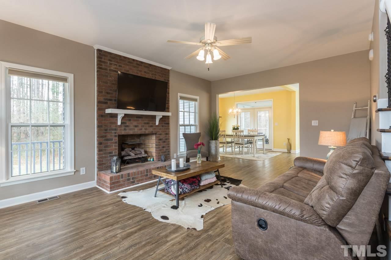 7505 Penny Road Raleigh, NC 27606 - Photo 5 of 25 a living room with furniture a flat screen tv and a fireplace