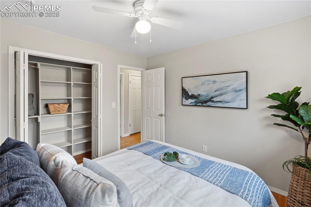 4127 Bent Drive Colorado Springs, CO 80909 - Photo 15 of 41 a bedroom with a large bed and a chandelier