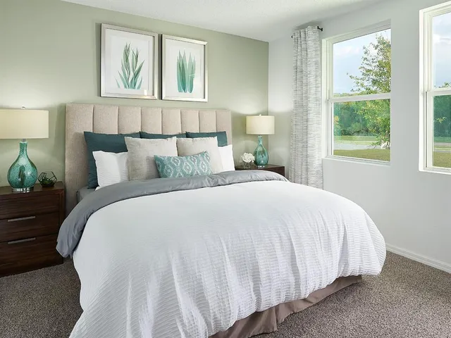 a large bed sitting in a bedroom next to a window