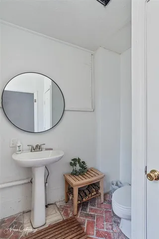 a bathroom with a toilet a sink and a mirror