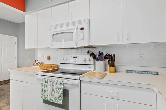 a kitchen with stainless steel appliances granite countertop a sink a stove and white cabinets