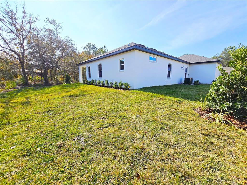 6 Calendula Court Homosassa, FL 34446 - Photo 24 of 67 a view of a backyard with plants and large tree