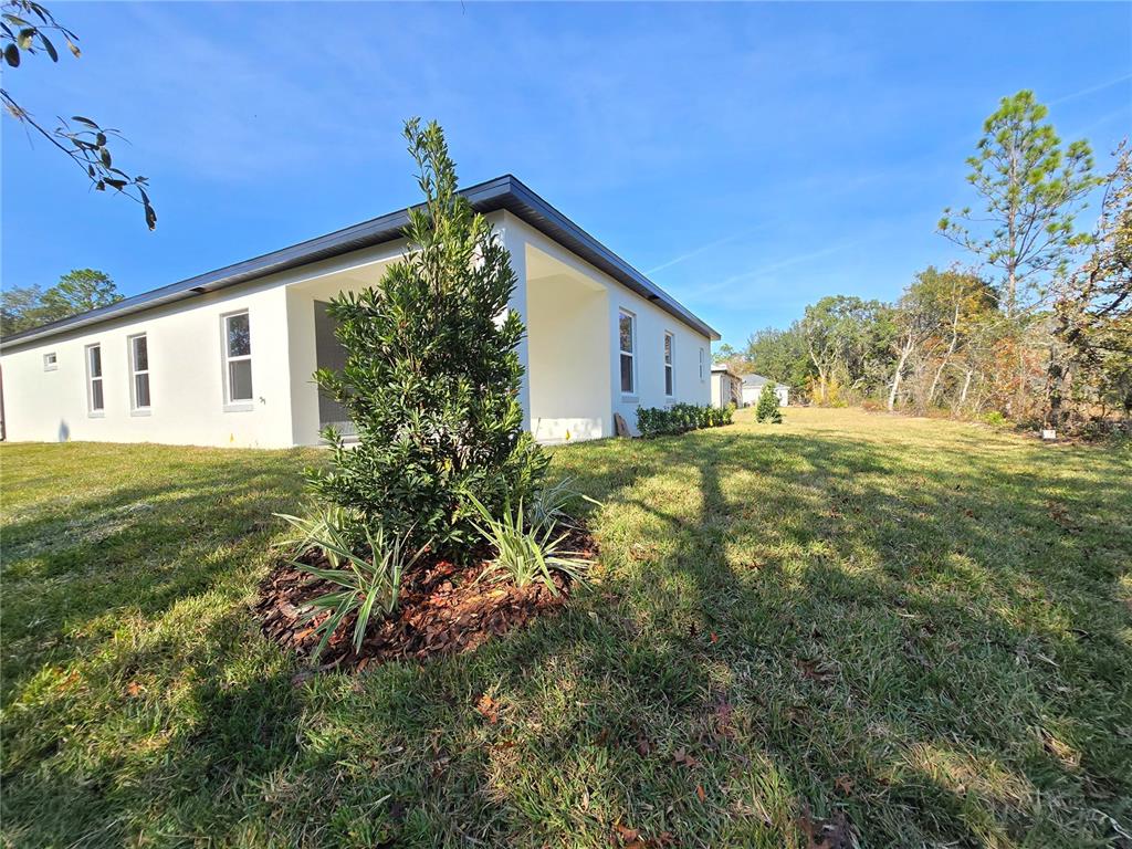 6 Calendula Court Homosassa, FL 34446 - Photo 65 of 67 a yellow house with lots of trees in the background