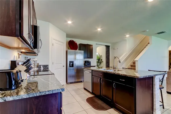 a kitchen with granite countertop stainless steel appliances a refrigerator and cabinets