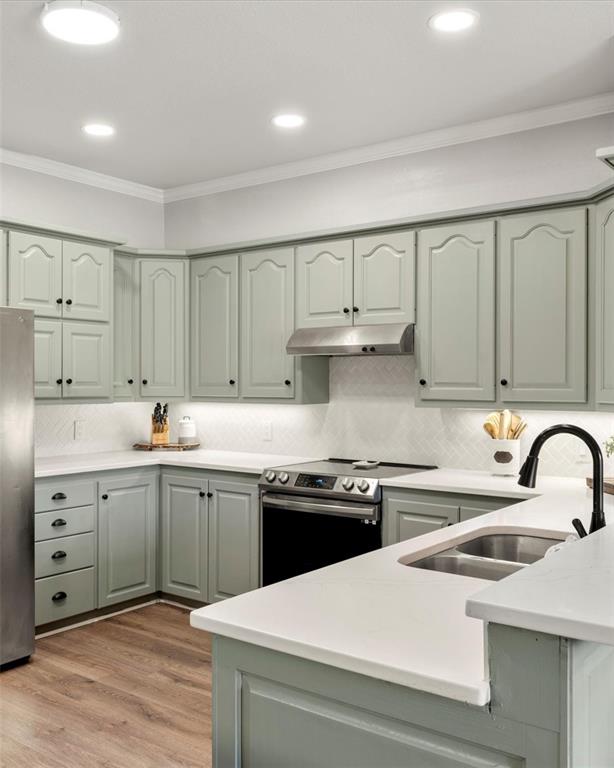 3006 Master Dr Mount Mount Pleasant, TX 75455 - Photo 11 of 34 a kitchen with a sink dishwasher a stove and white cabinets with wooden floor