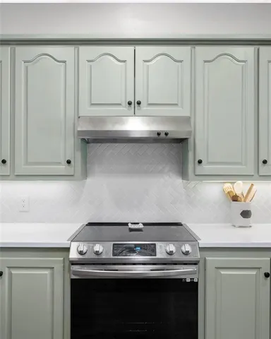 a stove top oven sitting inside of a kitchen