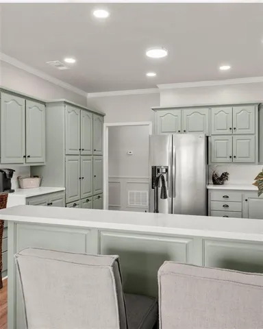 a kitchen with a refrigerator sink and cabinets