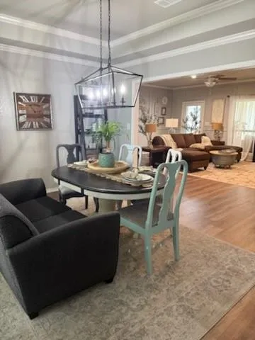 a dining room with furniture a chandelier and a large window