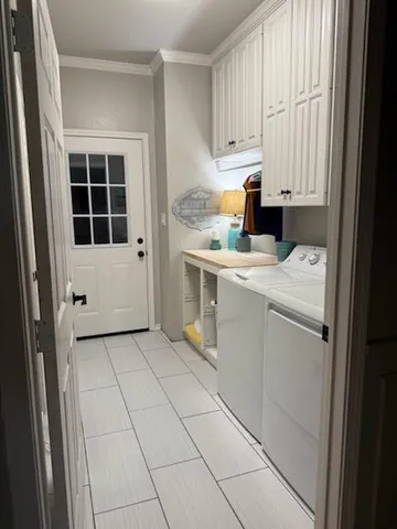 a utility room with cabinets washer and dryer