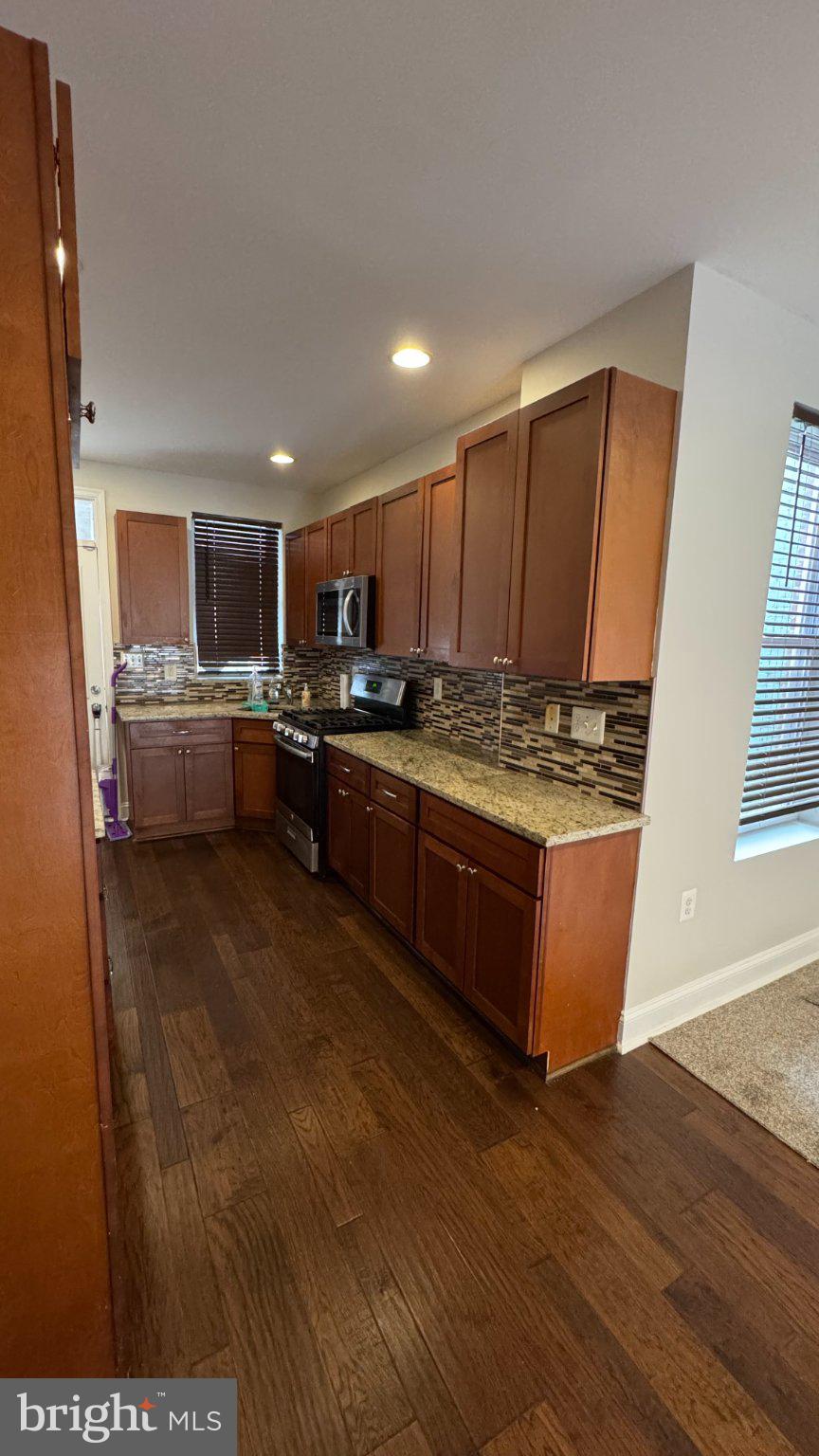 2705 East Biddle Street Baltimore, MD 21213 - Photo 3 of 12 a kitchen with stainless steel appliances granite countertop a stove sink and cabinets