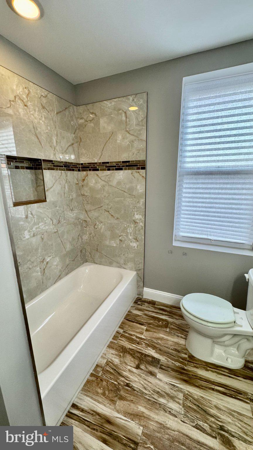 2705 East Biddle Street Baltimore, MD 21213 - Photo 8 of 12 a bathroom with a toilet a sink and a bathtub