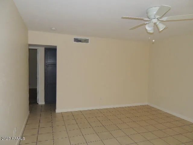an empty room with a ceiling fan and carpet