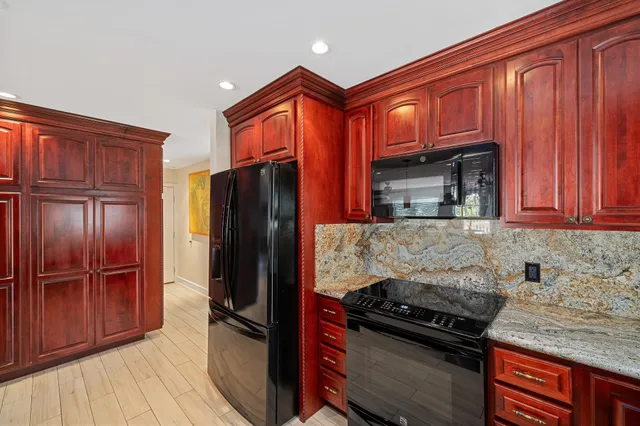 a kitchen with granite countertop a sink stove and microwave
