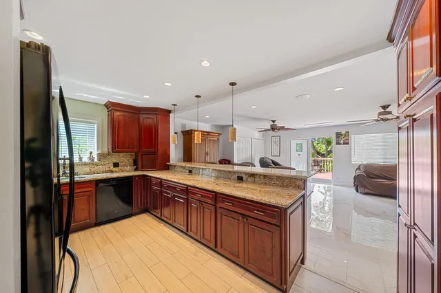 a large kitchen with stainless steel appliances granite countertop a stove and a sink