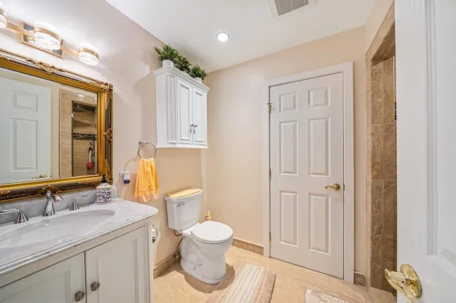 a bathroom with a granite countertop sink toilet and shower
