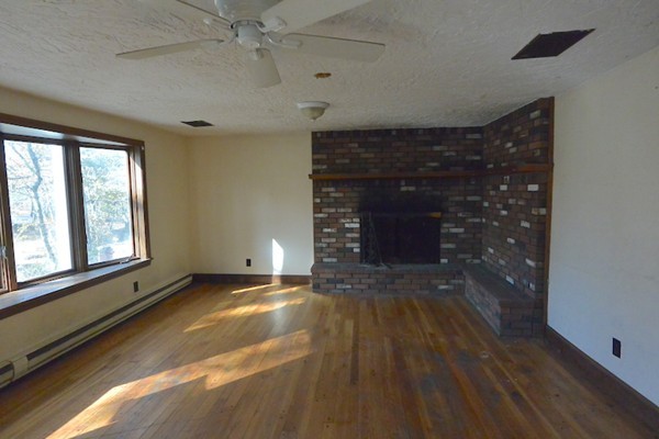 5 Spring Road Middleton, MA 01949 - Photo 4 of 16 a view of an empty room with a fireplace and a window