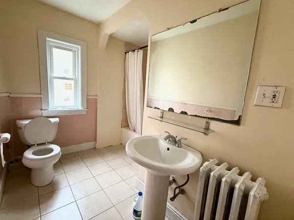 a bathroom with a sink toilet and a mirror