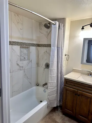 a bathroom with a bathtub vanity and a shower