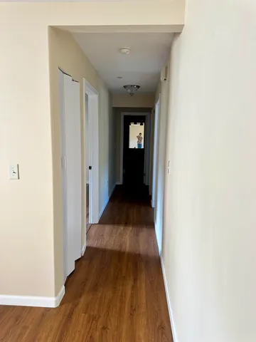 a view of a hallway with wooden floor