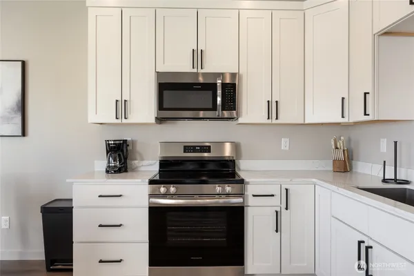 a kitchen with stainless steel appliances granite countertop a stove and a microwave