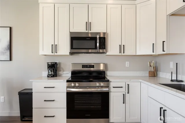 a kitchen with stainless steel appliances granite countertop a stove and a microwave