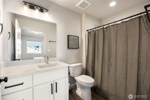 a bathroom with a toilet a sink and a mirror