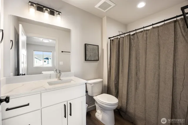 a bathroom with a toilet a sink and a mirror