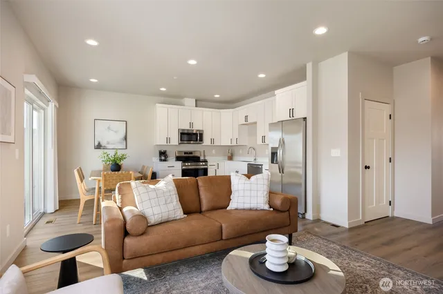a living room with furniture and a view of kitchen