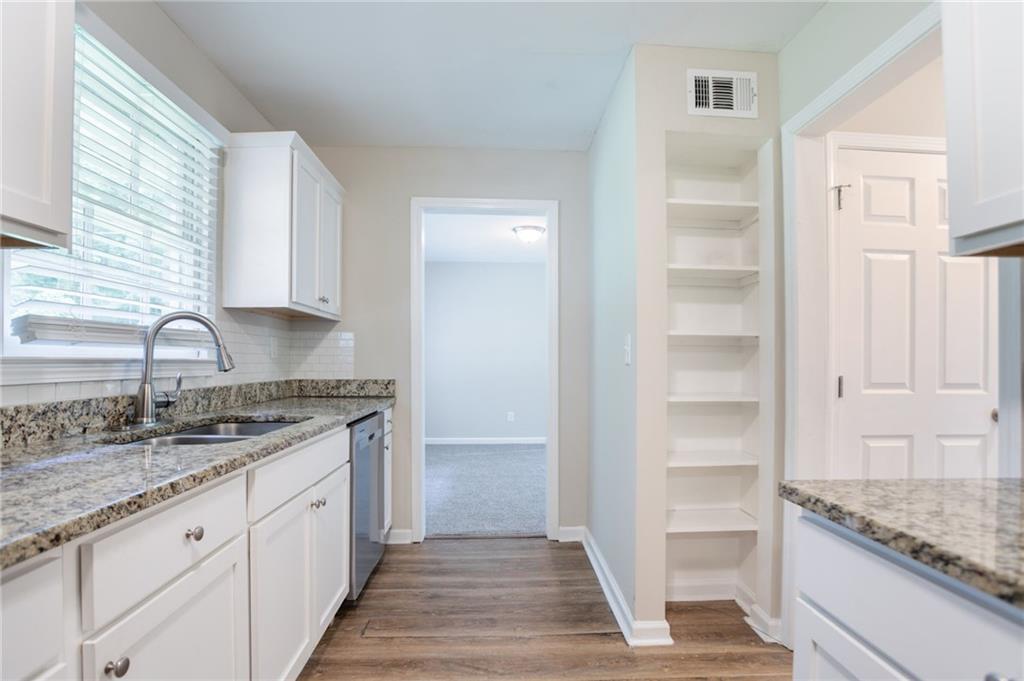 542 Hasty Drive Lithia Springs, GA 30122 - Photo 11 of 44 a kitchen with granite countertop a sink and cabinets