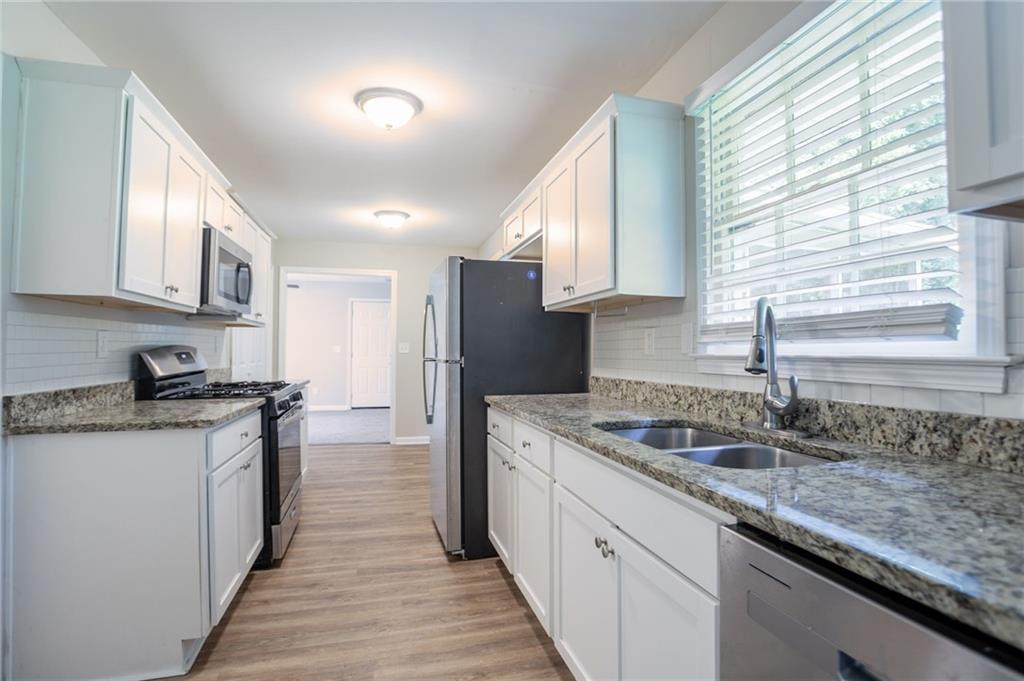 542 Hasty Drive Lithia Springs, GA 30122 - Photo 13 of 44 a kitchen with granite countertop kitchen island stainless steel appliances a sink stove and cabinets