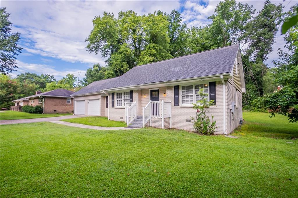 542 Hasty Drive Lithia Springs, GA 30122 - Photo 2 of 44 a front view of a house with a garden and trees